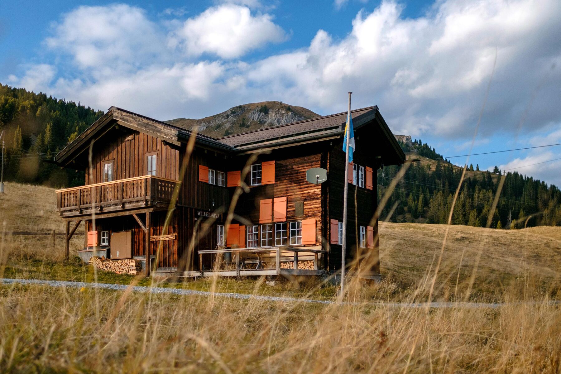 Die Fassade mit den orangen Läden, im Sommer