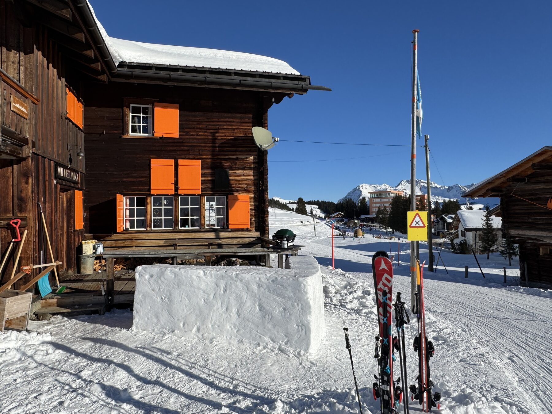 Das Chalet im Schnee, davor die Ski im Schneetisch