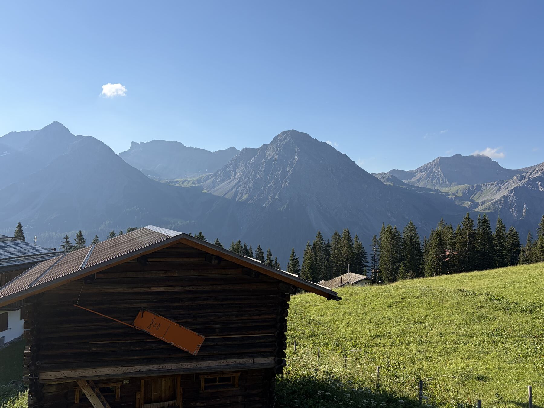 Morgens aus dem Elternzimmer: der alte Stall, die Bergwiese und die Gipfel über Arosa