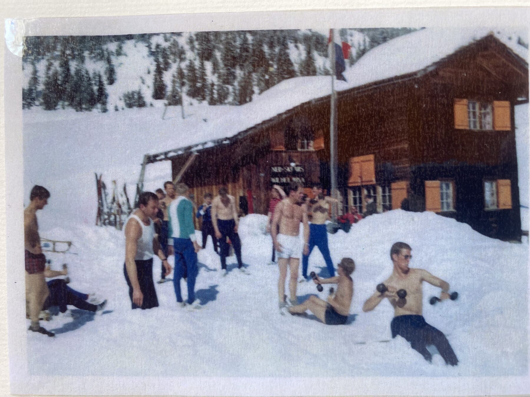Archivfoto: Sportler beim Training im Schnee vor dem Haus, daneben die niederländische Fahne