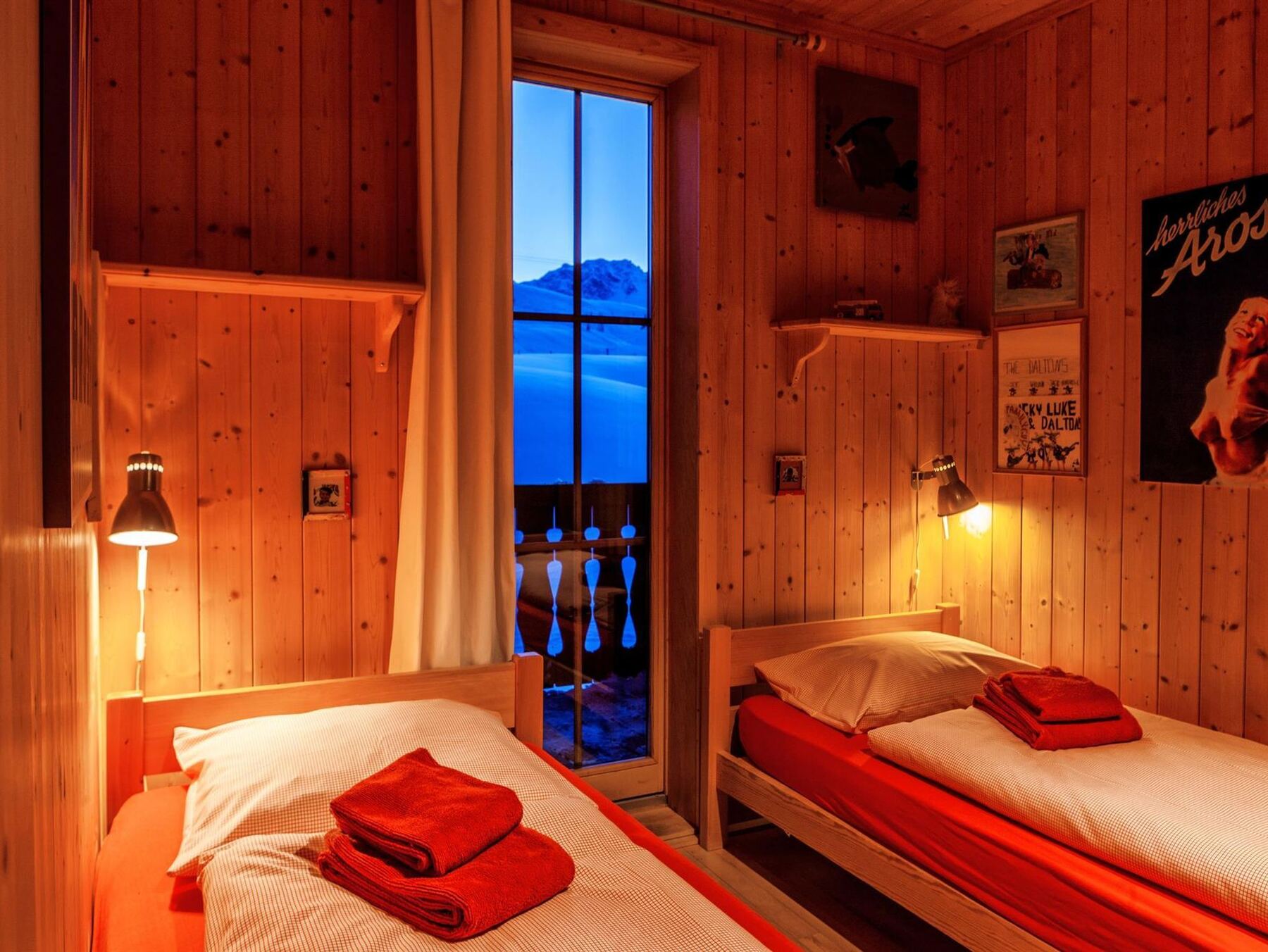 Ein Doppelzimmer mit zwei Betten und Tür zum Balkon