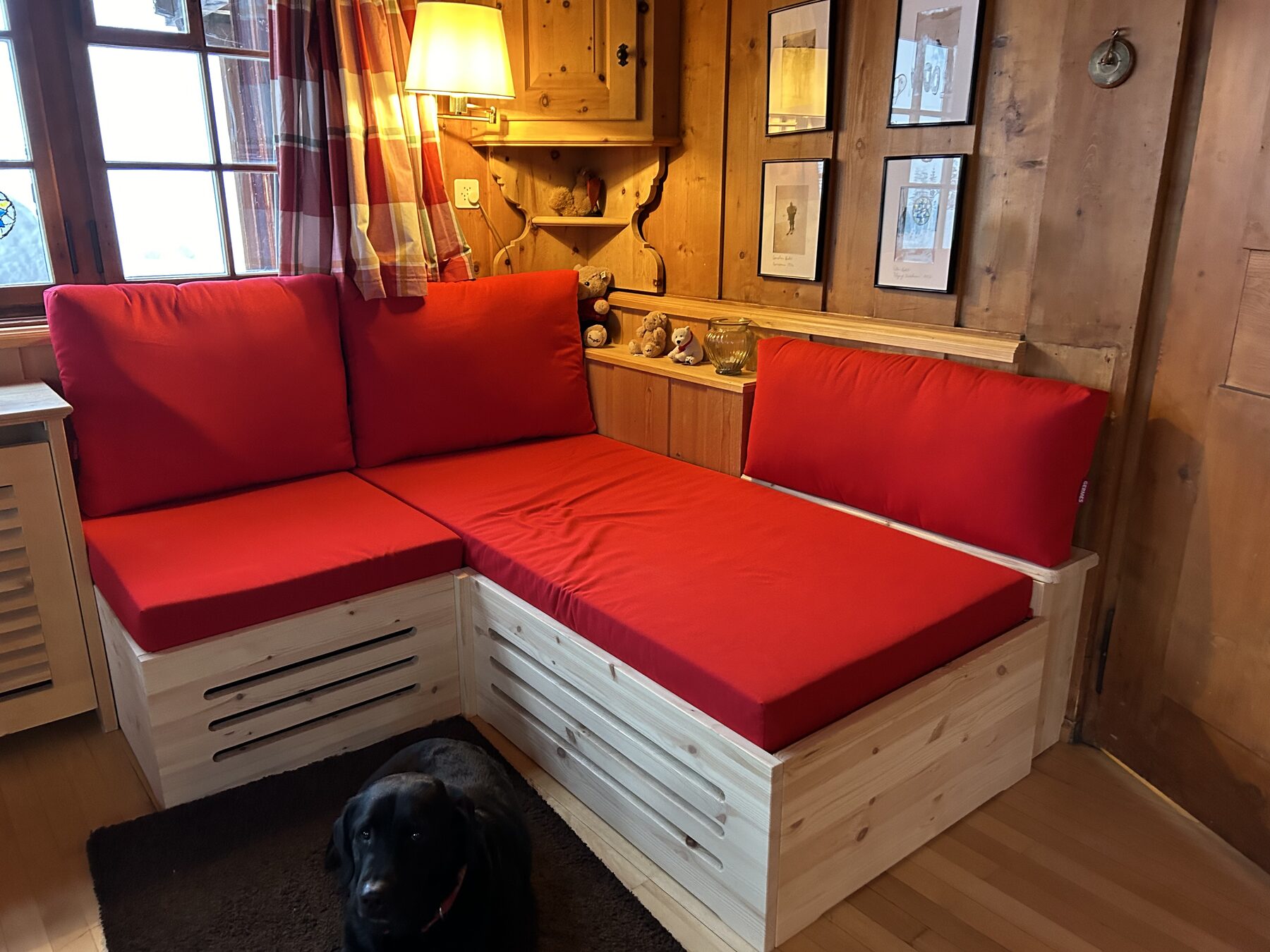 Die Sitzecke mit den roten Polstern, davor der Hund